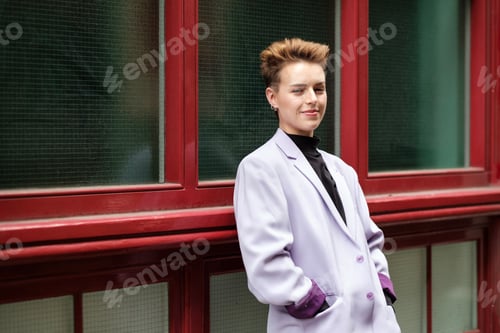 Preview: Sleepy alternative young woman leaning on red window in the street.