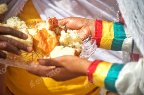 Preview: A generous diverse unrecognizable young woman distributes communion bread at outdoor worship