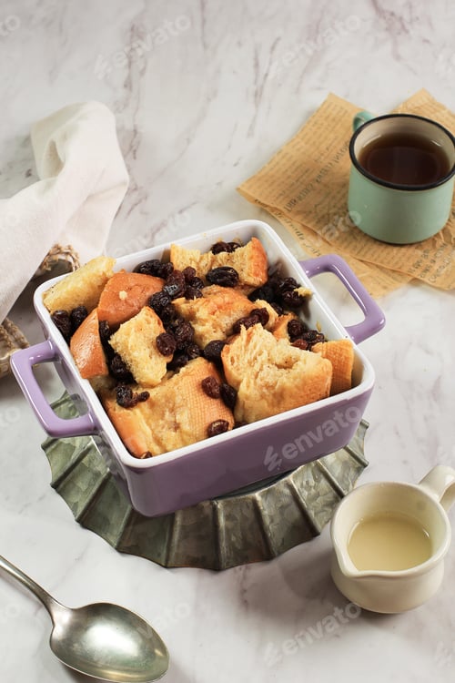 Preview: Close Up Cinnamon Bread and Butter Pudding with Raisins in Clear Baking Dish