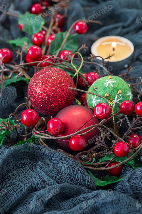 Preview: Christmas composition with holly, holiday balls and candle on dark background, vertical, copy space