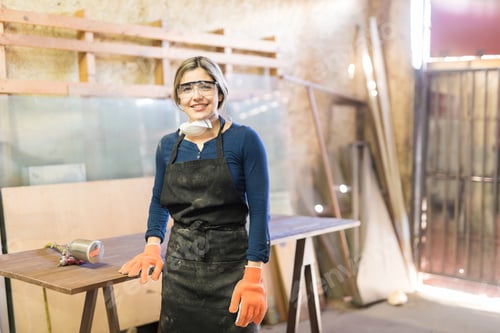 Preview: Beautiful female carpenter in a woodshop