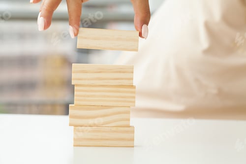Preview: Hand putting and stacking blank wooden cubes on table