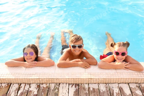 Preview: Happy children with sunglasses in swimming pool on sunny day