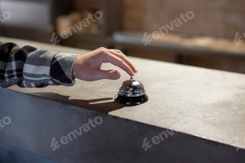 Preview: Customer Rings Service Bell at Counter in Casual Restaurant During Evening Hours