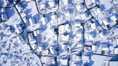 Preview: Bird's eye view of a a residential neighborhood covered in snow during the winter