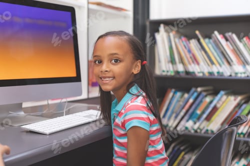 Preview: Portrait of happy African-american schoolgirl sitting and looking at camera in computer room