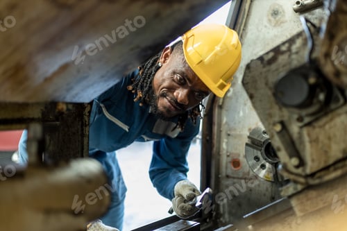 Preview: Male african american workers wear yellow hard hat holding wrench working on repairing factory machi