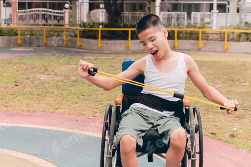 Preview: Asian special child on wheelchair using arm exercise equipment in house