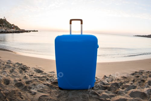 Preview: Travel, holiday and vacation concept - blue suitcase on the beach.