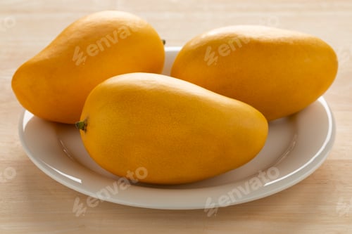 Preview: Plate with fresh sweet yellow Nam Dok Mai mango close up