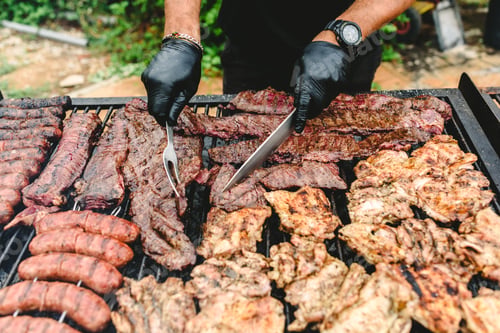 Preview: cook preparing grilled meat during a barbecue.