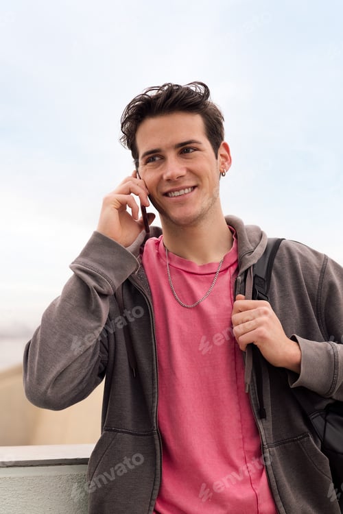 Preview: smiling happy young man talking on mobile phone