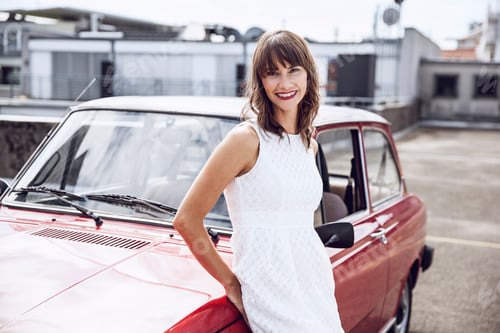 Preview: Beautiful woman leaning on vintage car