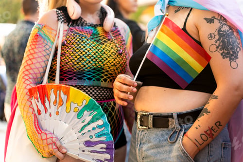 Preview: Lgbt activists holding rainbow flag and fan at pride parade