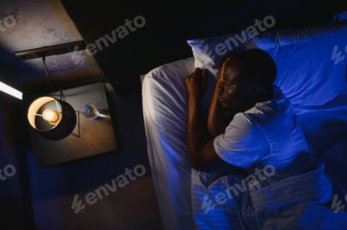 Preview: african American man sleeping in comfortable white bed seeing good pleasant dreams