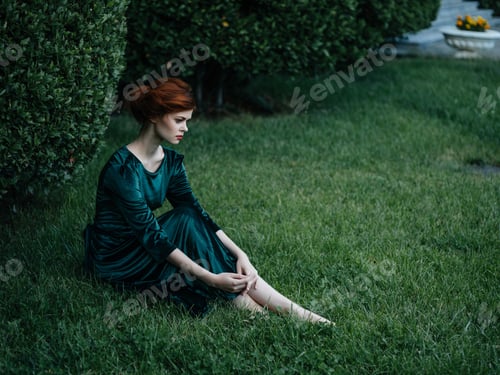 Preview: pretty woman in green dress sitting in the garden summer vacation