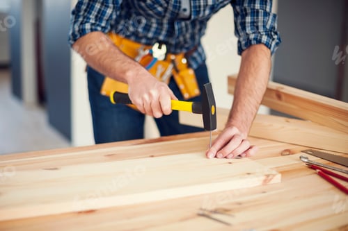 Preview: Close up of man hitting nail by hammer