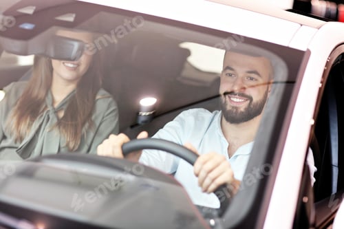 Preview: Adult couple choosing new car in showroom