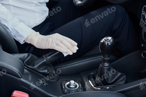 Preview: Woman cleaning car interior. Hand with an antibacterial wipe disinfect car