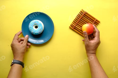 Preview: hand holding donuts and apple on hand on blue background