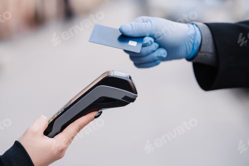 Preview: Faceless human in medical gloves during coronavirus epidemic, tries to makes cashless payment