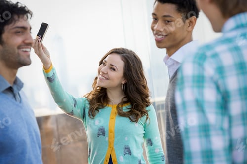 Preview: Observation deck in New York City, men and a woman taking a smart phone picture