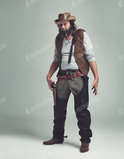 Preview: Lets draw. A grizzled senior cowboy looking confrontational while isolated on gray.