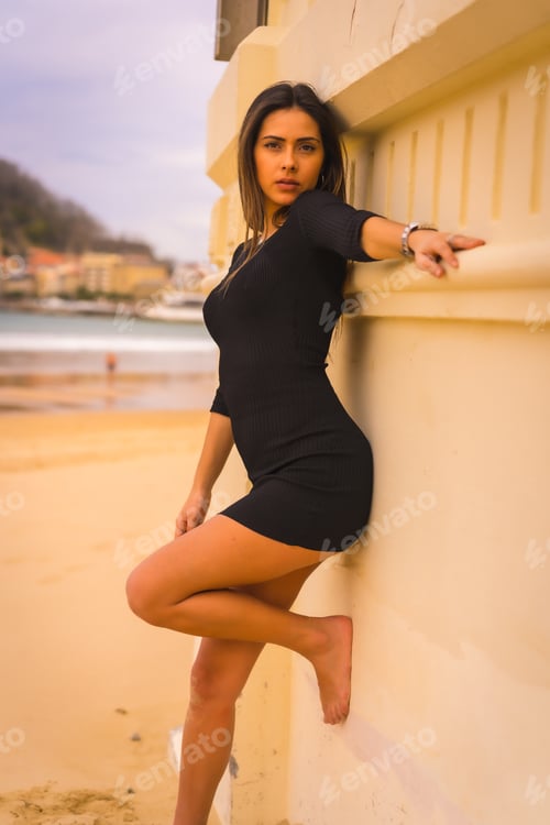 Preview: Portrait of a young brunette Caucasian from the back in a short black dress