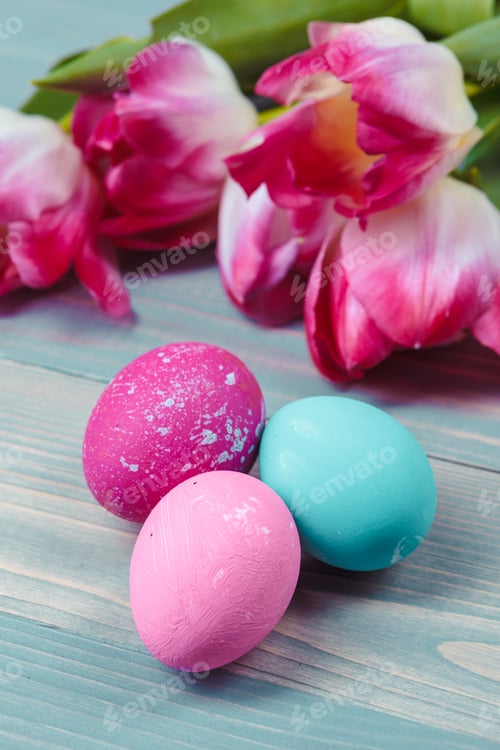 Preview: Easter eggs with tulips on blue wooden background