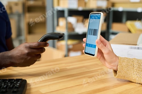 Preview: Black Man Scanning Barcode on Smartphone of Caucasian Woman