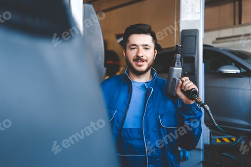Preview: Mechanic with a pneumatic wrench in his hands