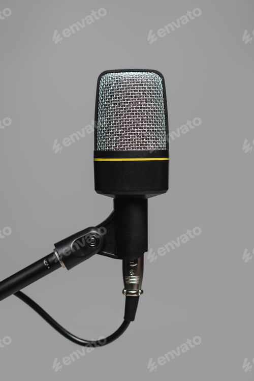Preview: Close up view of microphone with black wire on metal stand isolated on grey, studio photo