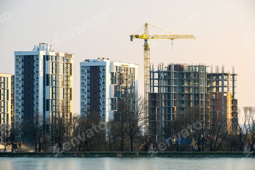 Preview: Tower crane and high residential apartment buildings under construction on lake shore.