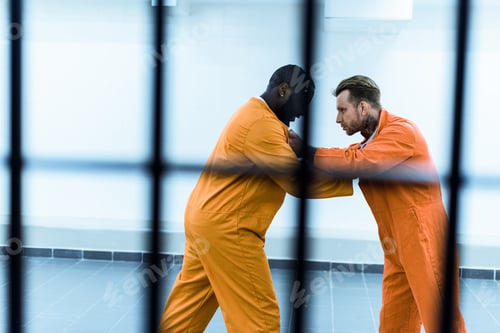 Preview: side view of multiethnic prisoners fighting behind prison bars