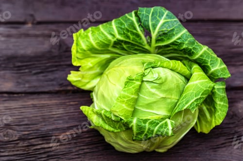 Preview: Green fresh cabbage head on wooden surface