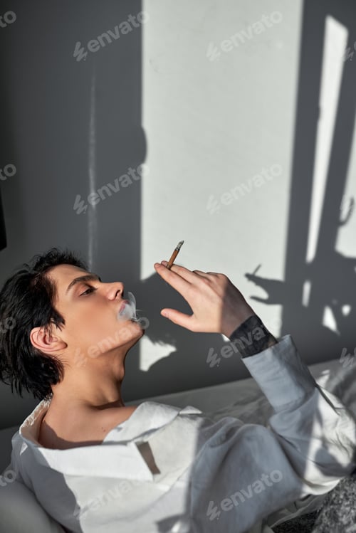 Preview: handsome man smoking cannabis weed at home and using his lighter