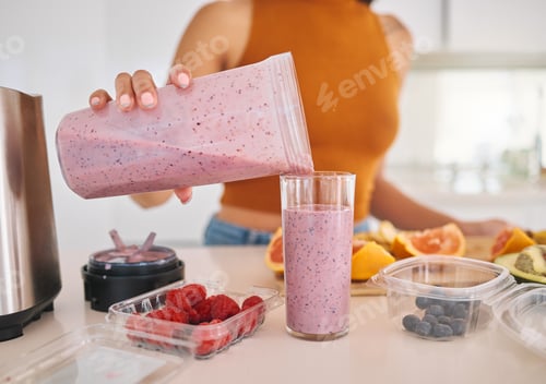 Preview: All that goodness in one glass. Cropped shot of a woman pouring a smoothie into a glass at home.