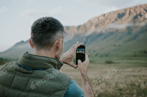 Preview: Man Taking Photo of Mountain Landscape with Phone