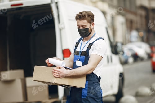 Preview: Delivery man with package outdoors