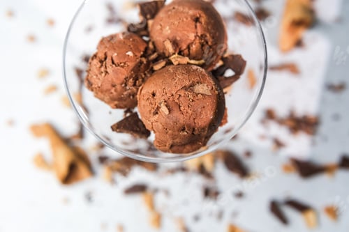 Preview: Top view of chocolate ice cream scoops in glass with waffle and chocolate pieces