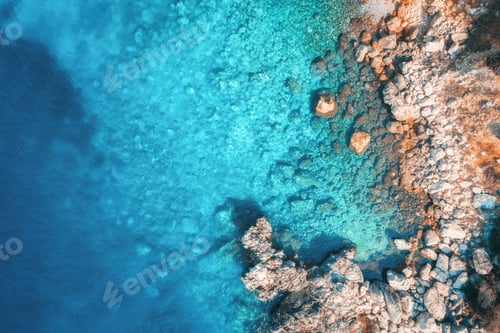 Preview: Aerial view of rocky beach and sea with transparent blue water