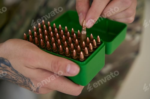 Preview: Army man picking up bullet from box of ammunition