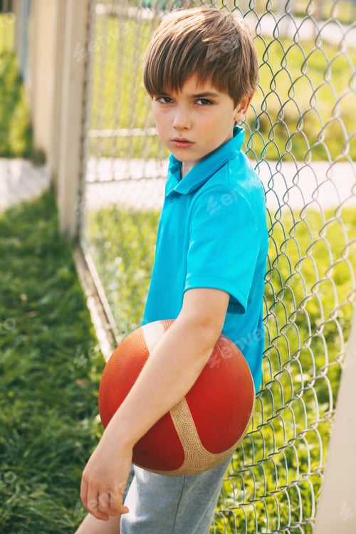 Preview: Portrait of a beautiful boy in a sports uniform with a basketball in his hands. Sports, education, h