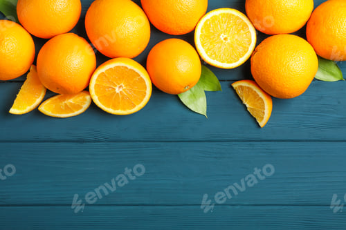 Preview: Flat lay composition with ripe oranges and leaves on wooden background. Top view, space for text