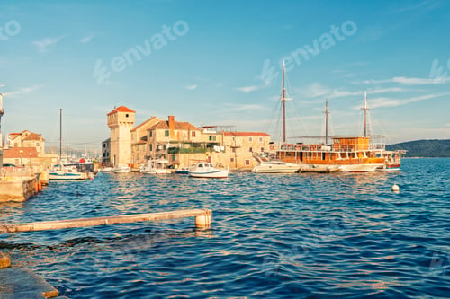 Preview: Cobblestone alley with historical stone buildings and an arched passageway in Trogir
