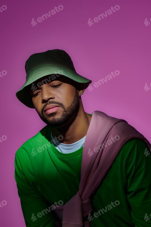 Preview: young african american male model with earring and sweatshirt tied on his shoulders, fashion concept