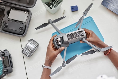 Preview: Top View Male Hands Holding Drone in Tech Repair Shop