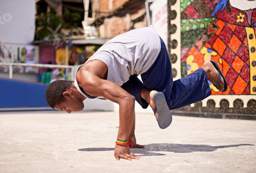 Preview: Capoeira culture. Low angle shot of a young male breakdancer in an urban setting.