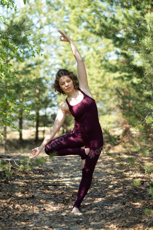 Preview: Young woman doing yoga outdoors in the park