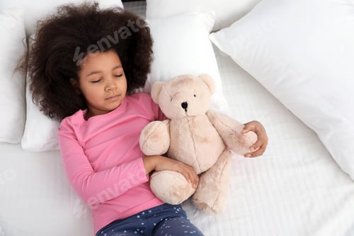 Preview: Cute little African-American girl with teddy bear sleeping in bed, top view